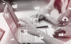 eine Person zeigt auf einen Laptop, über dem Bild sind verschiedene Digital-Icons mit einem Netz verbunden