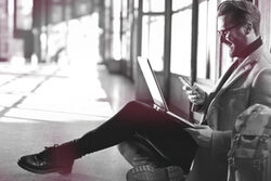 Mann mit Smartphone und Laptop